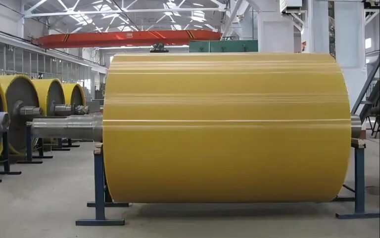 Large yellow covered roller on workshop supports